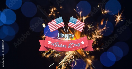 Composition of text happy labor day, with american flags and sparklers on dark blue with bokeh