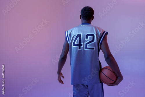 Basketball player with ball, black background