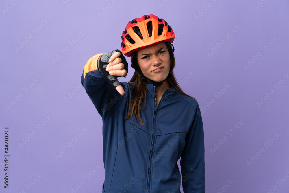 Teenager cyclist girl showing thumb down with negative expression Teenager cyclist girl showing thumb down with negative expression