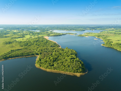 Beautiful aerial landscape on the lake with a drone. Many lake islands covered with forests, fields on a sunny day