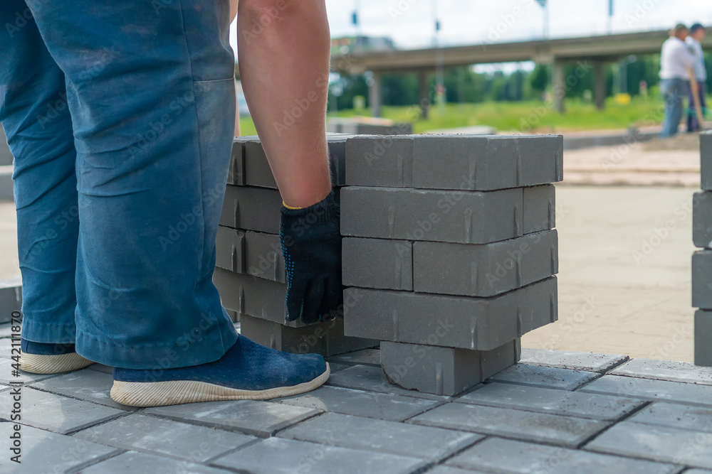 Working man takes a lot of concrete bricks and wants to move them to the right place