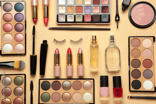 Different luxury makeup products on beige background, flat lay