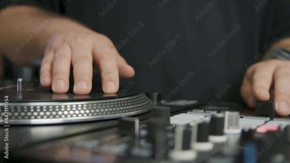 Hands of hip hop dj playing music filmed in slow motion. Professional disc jockey audio equipment on stage.Vinyl player turntable and sound mixer panel footage Hands of hip hop dj playing music filmed in slow motion. Professional disc jockey audio equipment on stage.Vinyl player turntable and sound mixer panel footage