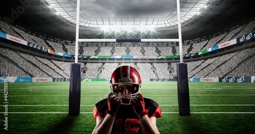 Composition of male american football player holding helmet at stadium