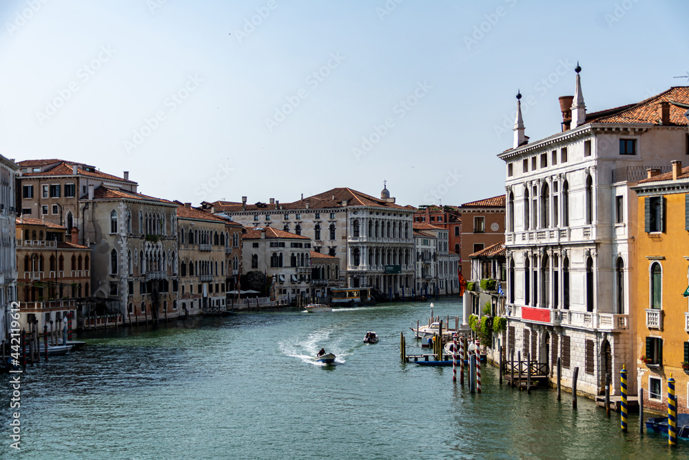 The quiet Grand Canal with a single boat sailing seen from the Ponte dell Accademia bridge on a sunny day in summer