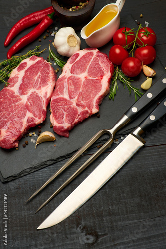 Fresh raw beef or pork steaks on stone cutting serving board