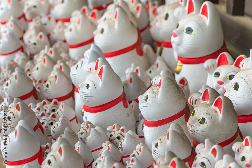 Bunch of kawaii Japanese manekineko cat lucky charms sculptures dedicated to the famous beckoning cat offered by worshippers in the buddhist gotokuji zen temple. Bunch of kawaii Japanese manekineko cat lucky charms sculptures dedicated to the famous beckoning cat offered by worshippers in the buddhist gotokuji zen temple.