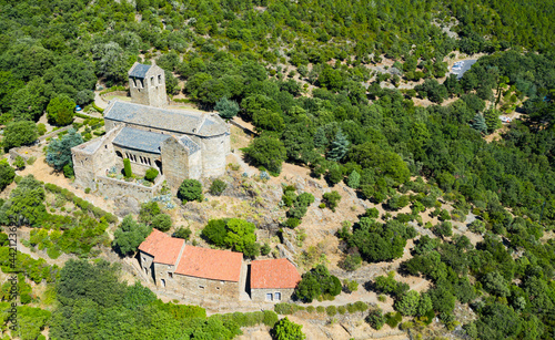 Scenic aerial view of ancient Romanesque building of Serrabone Priory in foothills of Canigou in summer, Pyrenees-Orientales, France.. photo