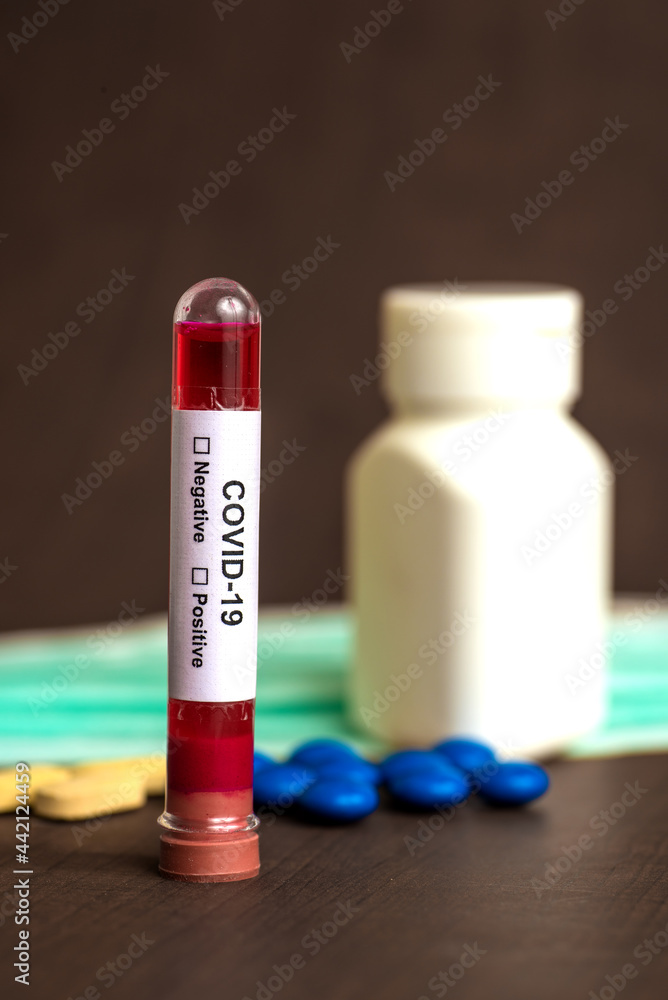 Tube containing a blood sample for testing to the presence of coronavirus / COVID-19 with Mask and medicine tablet. Tube containing a blood sample for testing to the presence of coronavirus / COVID-19 with Mask and medicine tablet.
