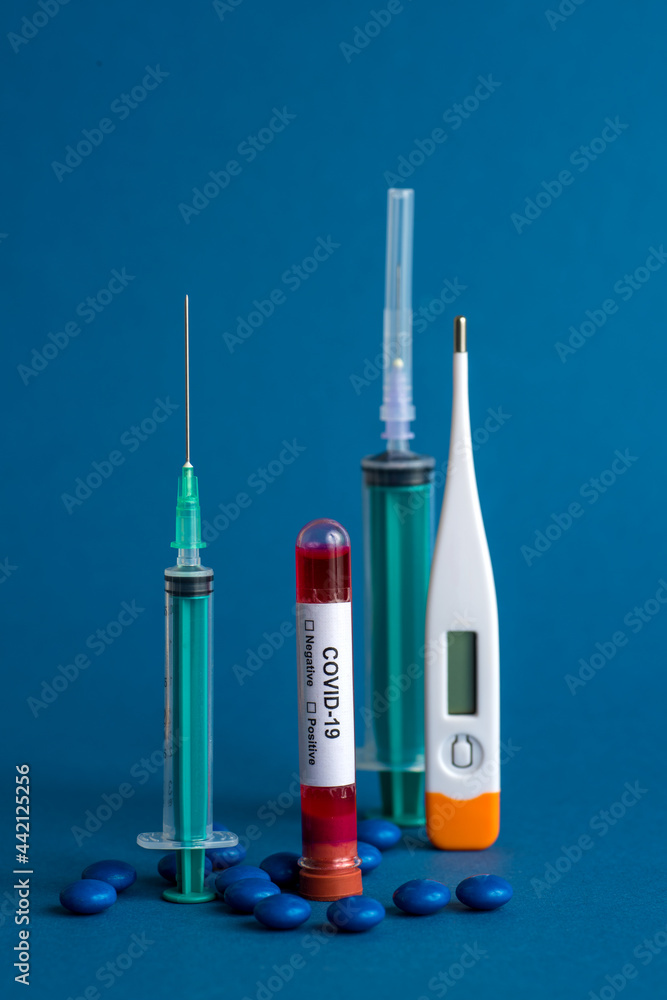 Medicine tablet, Thermometer and syringe or injection with a Test tube containing a blood sample for testing to the presence of coronavirus / COVID-19 Medicine tablet, Thermometer and syringe or injection with a Test tube containing a blood sample for testing to the presence of coronavirus / COVID-19