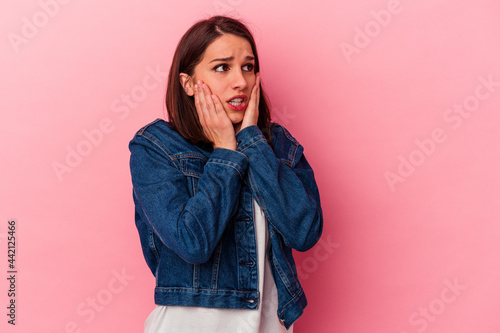 Young caucasian woman isolated on pink background scared and afraid. © Asier