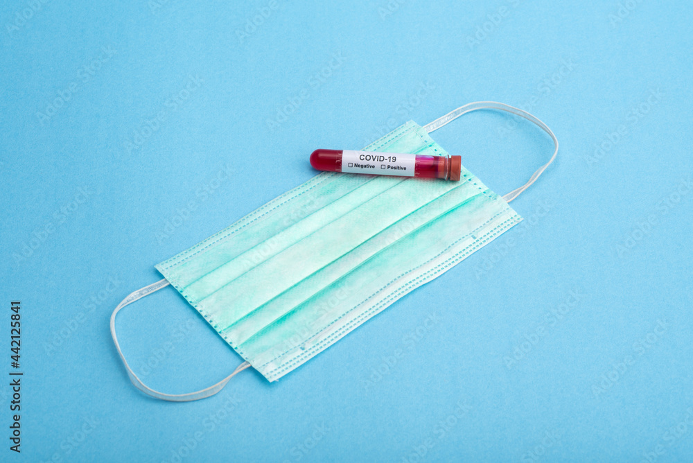 Tube containing a blood sample for testing to the presence of coronavirus / COVID-19 with a medical or surgical Mask Tube containing a blood sample for testing to the presence of coronavirus / COVID-19 with a medical or surgical Mask