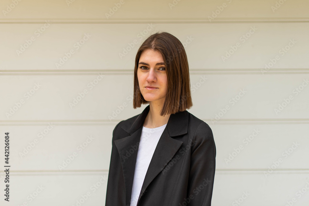 Business woman portrait outdoors. A young girl in business clothes poses for a photo session for resume.
