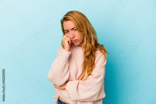 Caucasian woman isolated on blue background tired of a repetitive task.