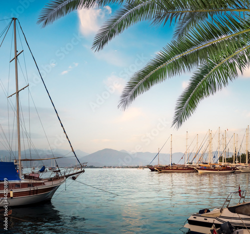 Fethiye Harbour at sunset with boats and yachts on a pier, Turkey. Turkish resort town Fethiye of the coast of the Aegean Sea.