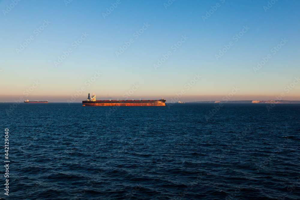 The bulk carrier is anchored at sea.