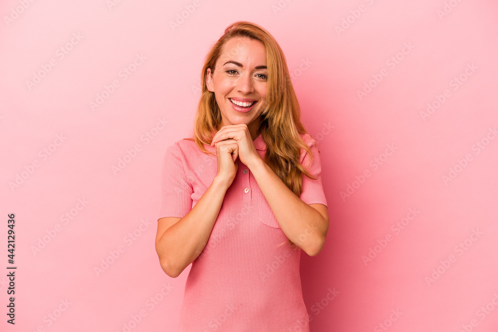 Caucasian blonde woman isolated on pink background praying for luck, amazed and opening mouth looking to front. Caucasian blonde woman isolated on pink background praying for luck, amazed and opening mouth looking to front.