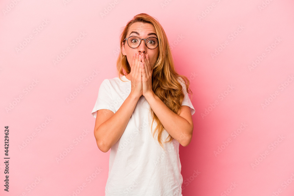 Caucasian blonde woman isolated on pink background shocked covering mouth with hands. Caucasian blonde woman isolated on pink background shocked covering mouth with hands.