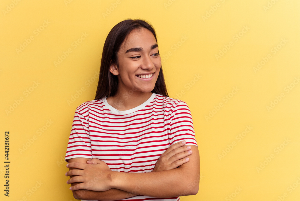 Obraz premium Young mixed race woman isolated on yellow background smiling confident with crossed arms.