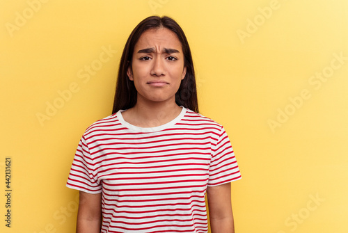 Young mixed race woman isolated on yellow background sad, serious face, feeling miserable and displeased.