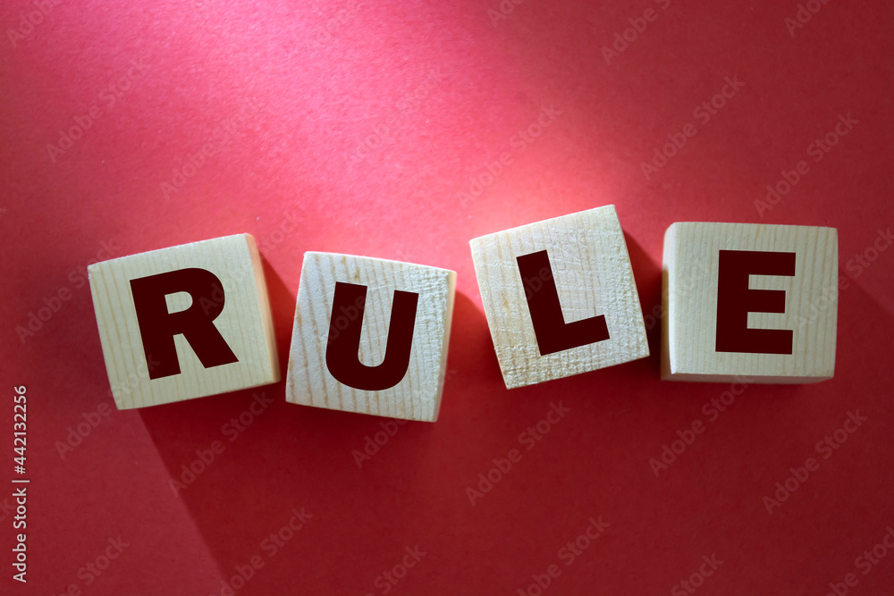 Obraz premium Wooden cube block with RULE business word on table background. Mission, Vision and core values concept