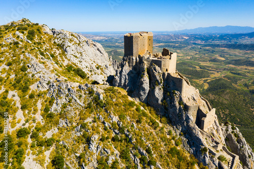 Aerial view of stone ruins of ancient fortified Chateau de Queribus on rocky hilltop on sunny summer day, Aude departement, France.. photo