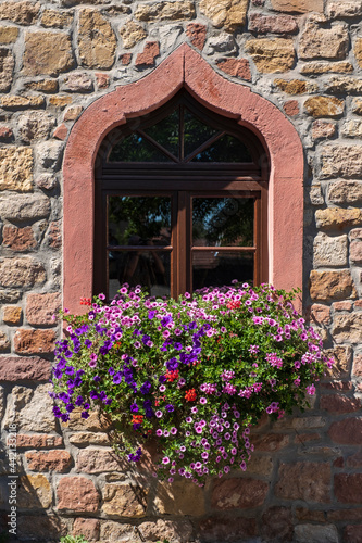 Old window in an old stone house with decorative flowers in Kirchheimbolanden / Germany 