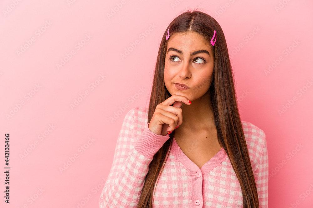 Young caucasian woman isolated on pink background looking sideways with doubtful and skeptical expression. Young caucasian woman isolated on pink background looking sideways with doubtful and skeptical expression.