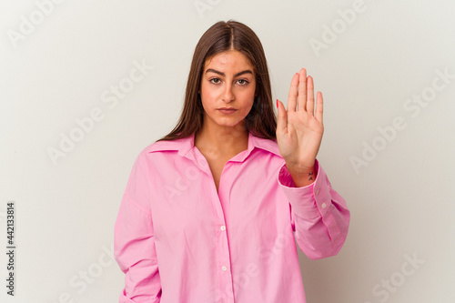 Young caucasian woman isolated on white background standing with outstretched hand showing stop sign, preventing you.