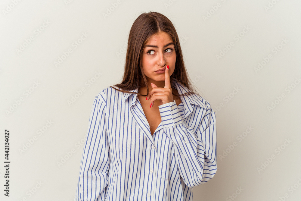 Obraz premium Young caucasian woman isolated on white background looking sideways with doubtful and skeptical expression.