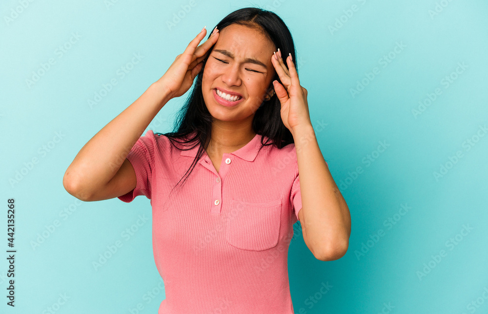 Young Venezuelan woman isolated on blue background touching temples and having headache. Young Venezuelan woman isolated on blue background touching temples and having headache.