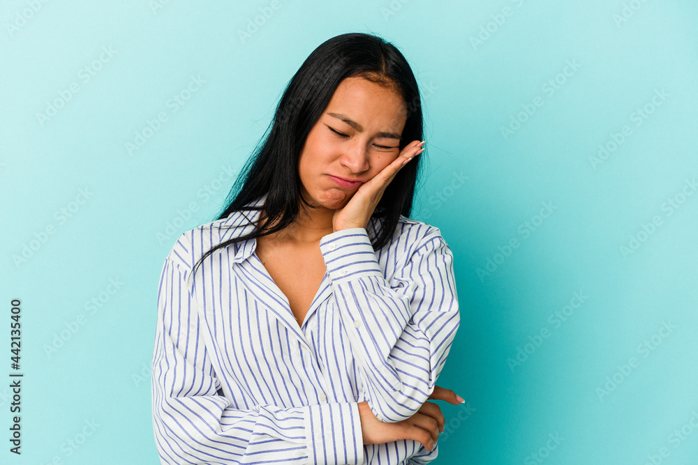 Young Venezuelan woman isolated on blue background who is bored, fatigued and need a relax day. Young Venezuelan woman isolated on blue background who is bored, fatigued and need a relax day.