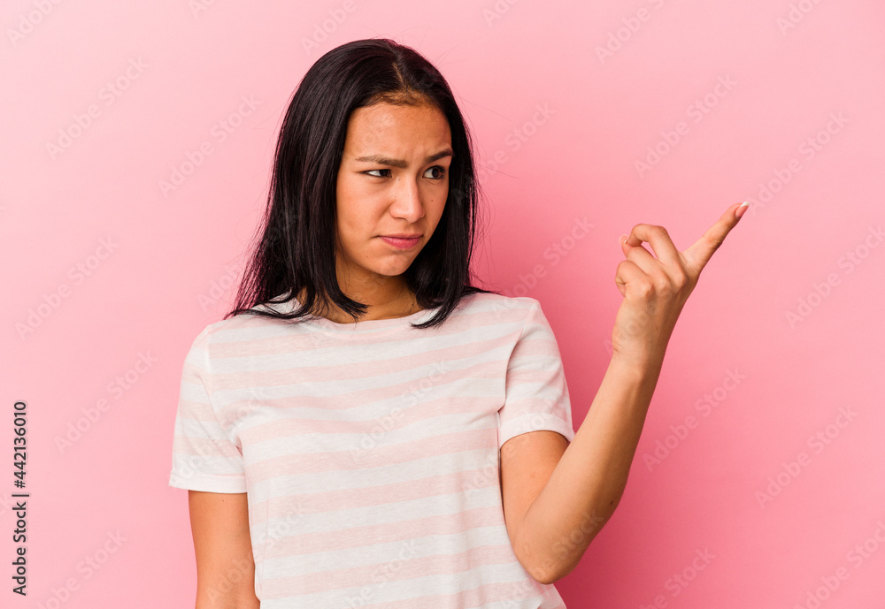Young Venezuelan woman isolated on pink background pointing with finger at you as if inviting come closer. Young Venezuelan woman isolated on pink background pointing with finger at you as if inviting come closer.