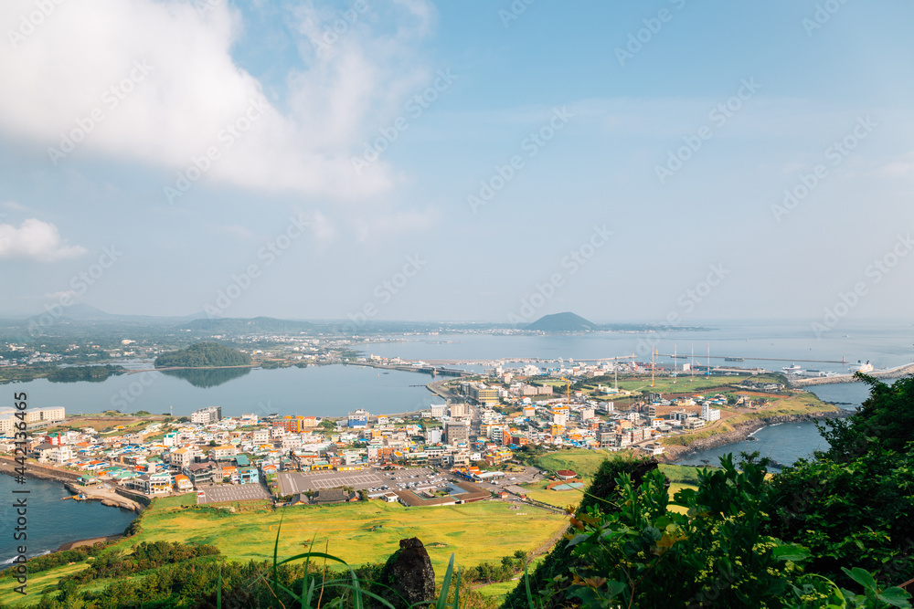 Obraz premium Panoramic view of seaside village from Seongsan Ilchulbong Tuff Cone in Jeju Island, Korea