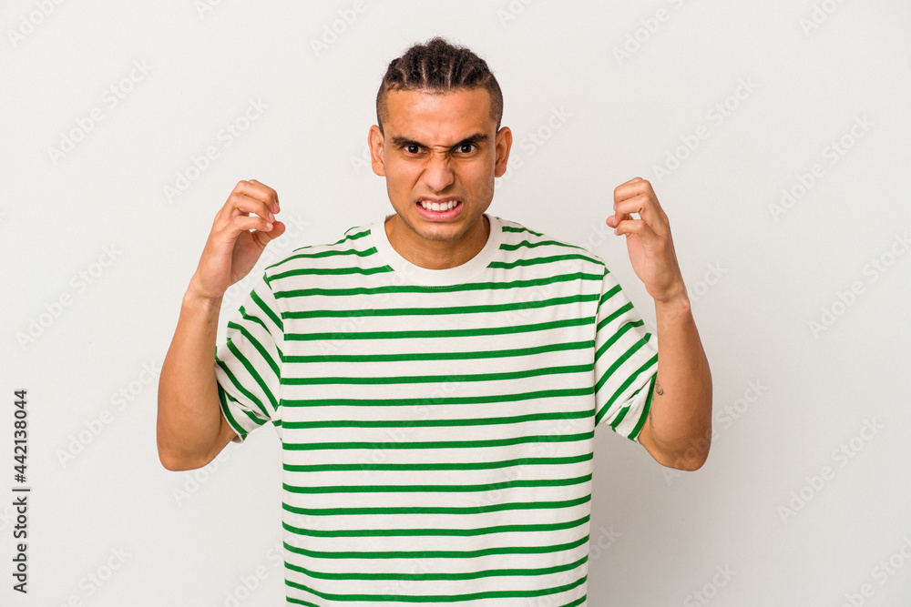 Young venezuelan man isolated on white background upset screaming with tense hands. Young venezuelan man isolated on white background upset screaming with tense hands.