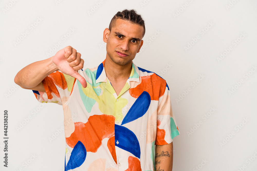 Young venezuelan man isolated on white background showing a dislike gesture, thumbs down. Disagreement concept. Young venezuelan man isolated on white background showing a dislike gesture, thumbs down. Disagreement concept.