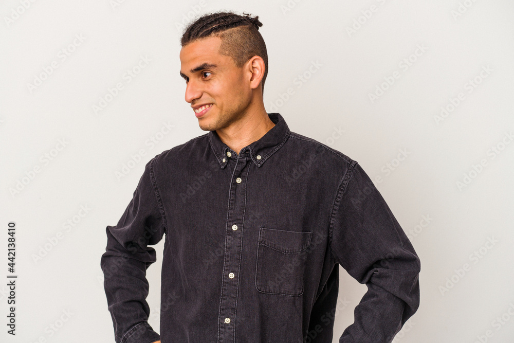 Obraz premium Young venezuelan man isolated on white background confident keeping hands on hips.