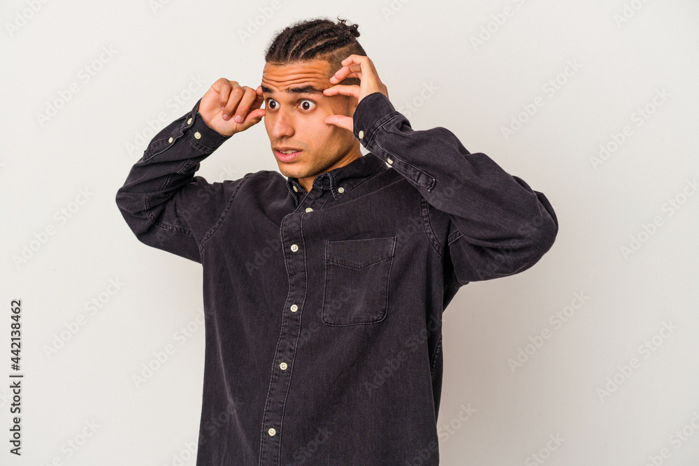 Young venezuelan man isolated on white background keeping eyes opened to find a success opportunity. Young venezuelan man isolated on white background keeping eyes opened to find a success opportunity.