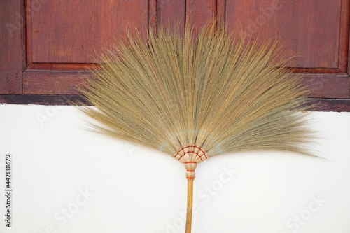 Concept : Cleaning equipment. Broom on house wall background.