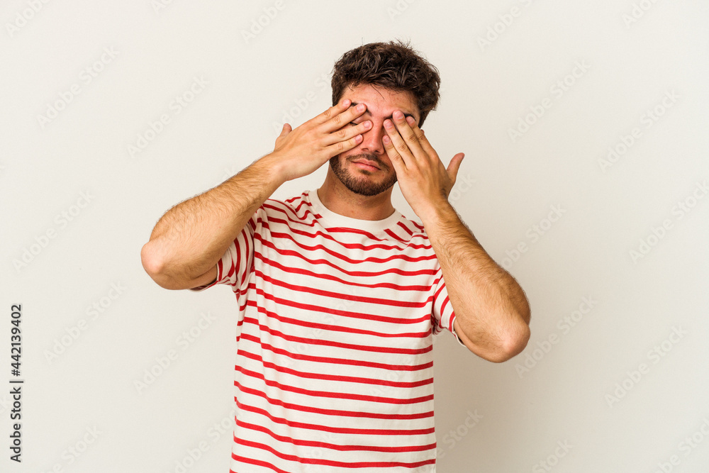 Young caucasian man isolated on white background afraid covering eyes with hands. Young caucasian man isolated on white background afraid covering eyes with hands.