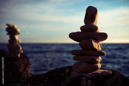 Photography Zen stones on a ocean sea cliff in sunset sunrise time.