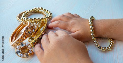 womens happiness - childrens hands play with gold jewelry and bijouterie, on white background