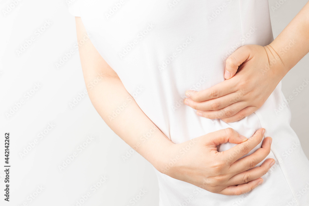 Young woman suffering from backache and flank pain on white background.  Cause of pain include UTI, kidney stones, gallbladder disease or muscle  problems. Health care and medical concept. Stock Photo