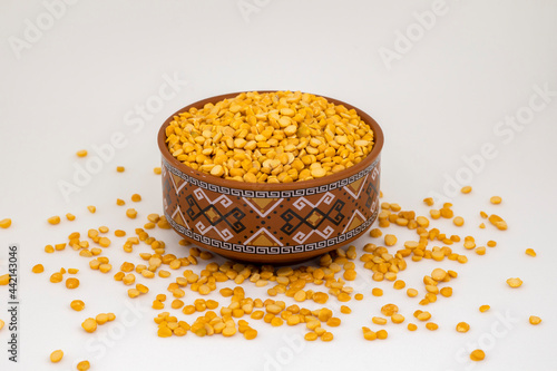 Close-up of Organic Bengal Gram (Cicer arietinum) or split yellow chana dal inside a  bowl. White isolated background.