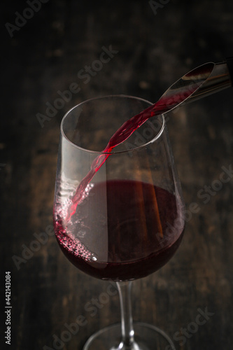 pouring a glass of wine on a wooden table
