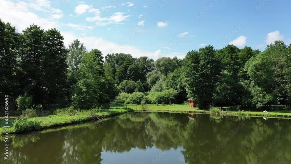Scenic natural landscape. Water, green trees, sky. Sunny summer day. Drone view, pull in shot Scenic natural landscape. Water, green trees, sky. Sunny summer day. Drone view, pull in shot