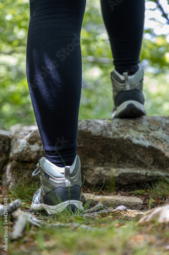 Boot of hiker on forest trail. Traveler feet are stepping on the rock . Adventure and hiking concept outdoor. Hipster lifestyle