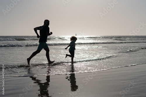 daddy with kid boy silhouette in sea or ocean. weekend family day. dad and child having fun