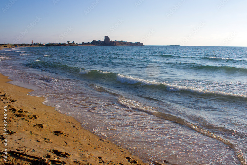 Beautiful seascape. Golden sand beach. Summer Idyllic  scenery. Calm blue water. Vacation time. Sun reflections on blue sea water. Evening on a beach. Calm waves and golden sand. Summer scenery.