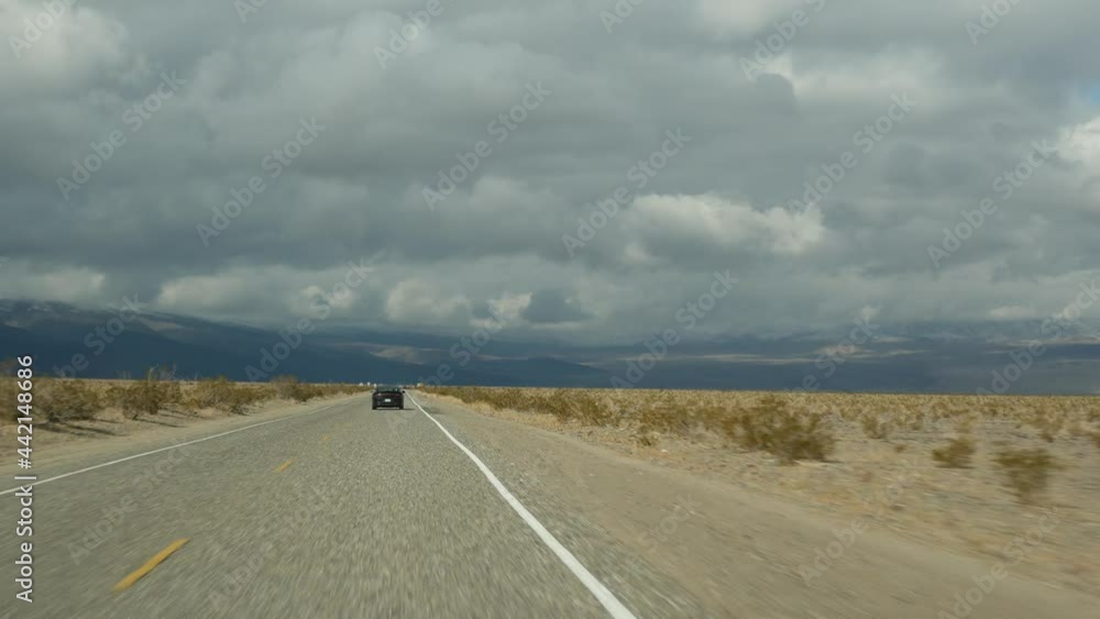 Road trip to Death Valley, driving auto in California, USA. Hitchhiking traveling in America. Highway, mountains and dry desert, arid climate wilderness. Passenger POV from car. Journey to Nevada. Road trip to Death Valley, driving auto in California, USA. Hitchhiking traveling in America. Highway, mountains and dry desert, arid climate wilderness. Passenger POV from car. Journey to Nevada.